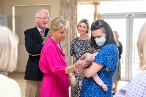 HRH Sophie, Countess of Wessex greets mother and baby at the Charlbury Community Centre as Chairman of the Thomas Gifford Trust; Chris Potts and the Centre Manager; Daniela Jenkins look on